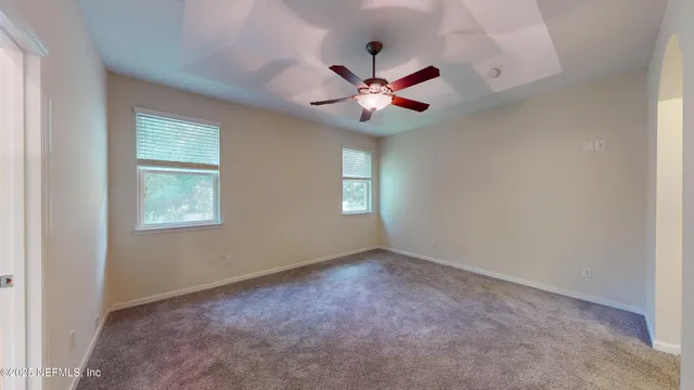 an empty room with a window and a fan