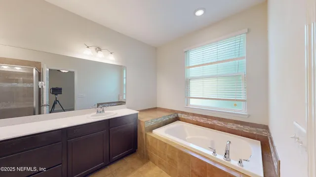 a bathroom with a bathtub sink and mirror