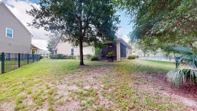 a view of a house with backyard and tree