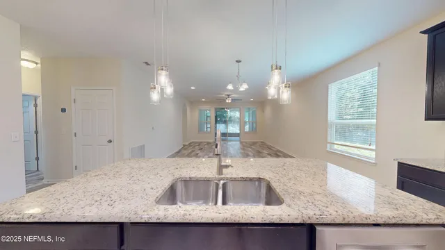 a kitchen with kitchen island granite countertop a sink and a window