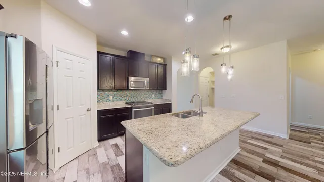 a kitchen with kitchen island a sink stove and refrigerator