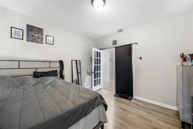 a bedroom with a bed and a refrigerator