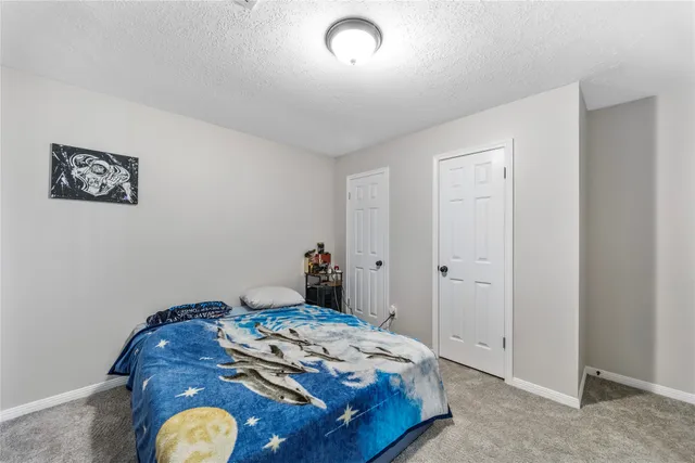 a bedroom with a bed and painting on the wall