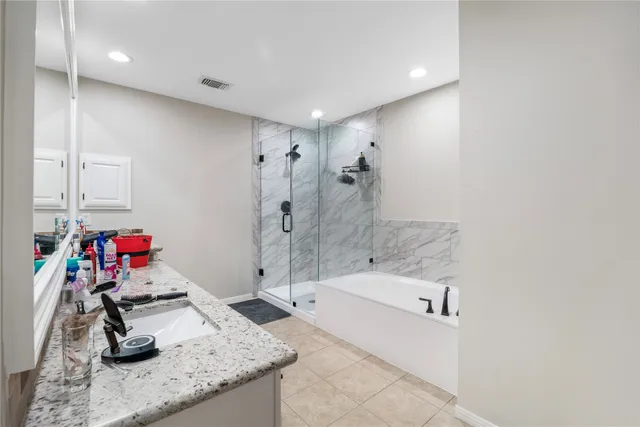 a bathroom with a granite countertop sink a mirror and shower