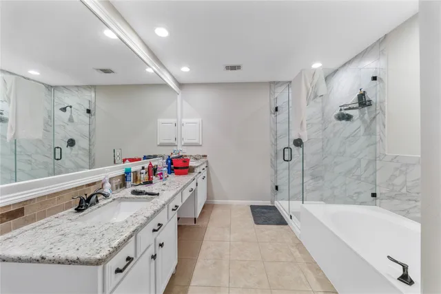 a bathroom with a granite countertop tub sink and mirror