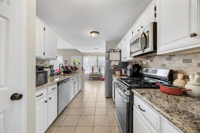 a kitchen with stainless steel appliances granite countertop a stove and cabinets