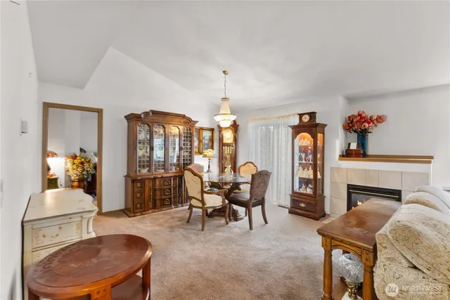 a living room with furniture a fireplace and a chandelier