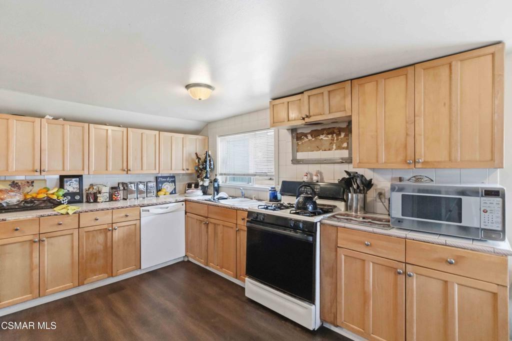 2874 School Street Simi Valley, CA 93065 - Photo 7 of 48 a kitchen with stainless steel appliances granite countertop white cabinets sink and window
