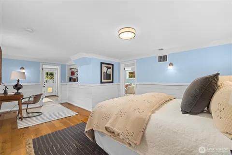 a bedroom with a bed and wooden floor