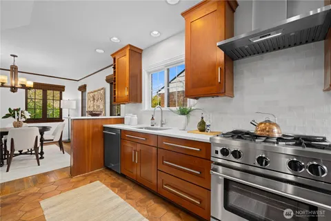 a kitchen with stainless steel appliances a stove a sink and cabinets