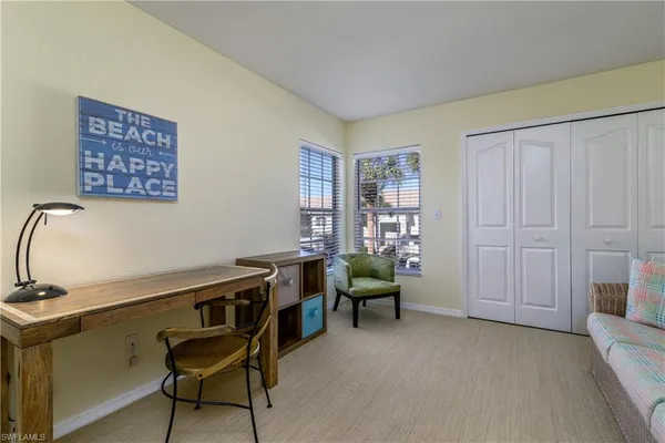 a view of a workspace with furniture and a window