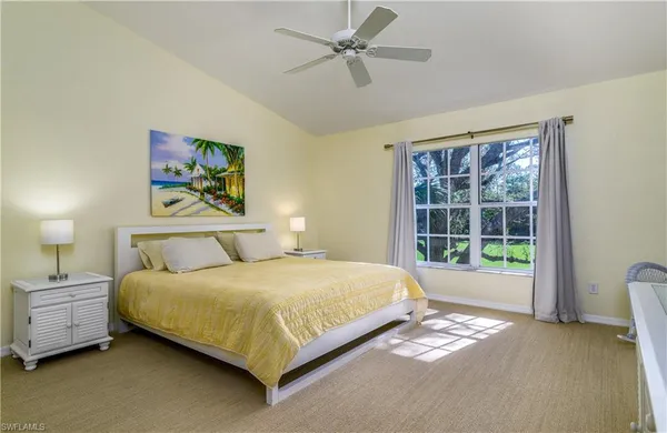 a bedroom with a bed painting and a window