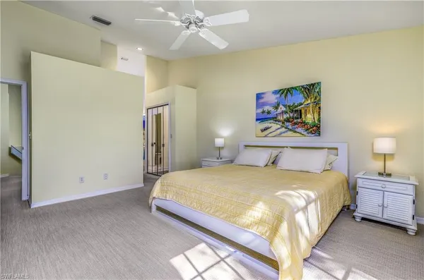 a bedroom with a bed and painting on the wall