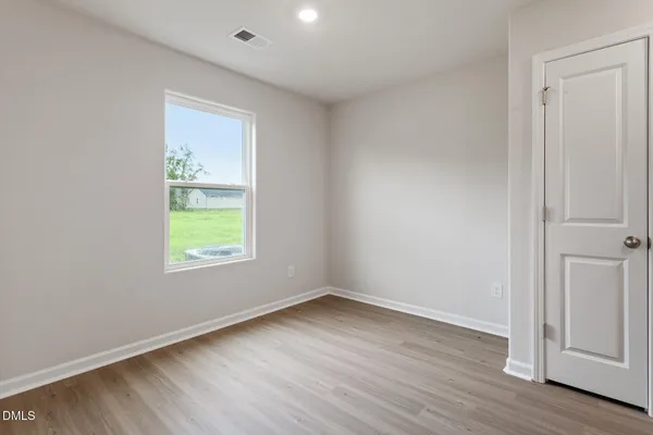an empty room with wooden floor and window