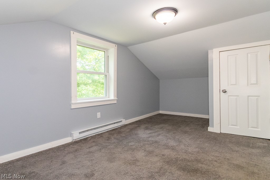 16506 Leroy Thompson Road Thompson, OH 44086 - Photo 40 of 41 Additional living space with a baseboard radiator, dark carpet, and lofted ceiling