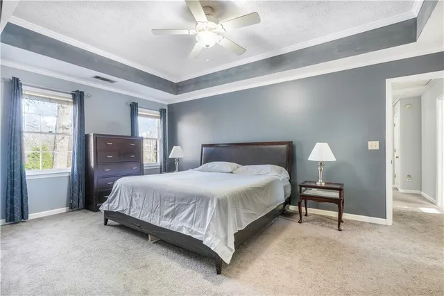 a bedroom with a bed and a lamp on dresser