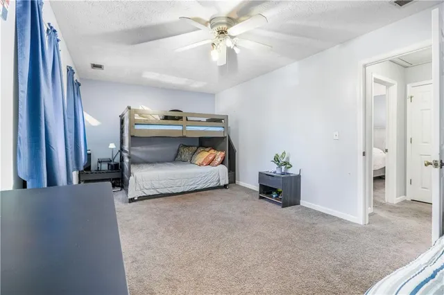 a bedroom with furniture and a chandelier fan