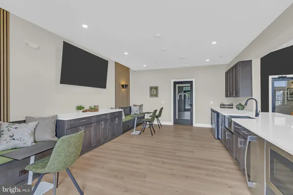 a large living room with stainless steel appliances granite countertop furniture a fireplace and a flat screen tv