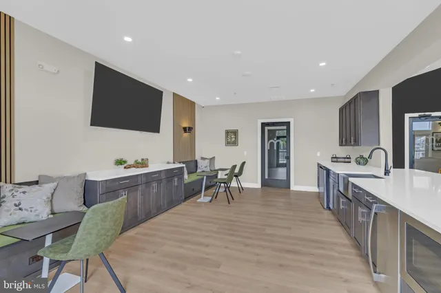 a large living room with stainless steel appliances granite countertop furniture a fireplace and a flat screen tv