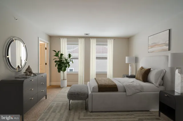 a bedroom with a large bed and a potted plant