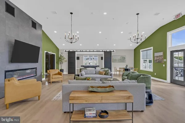 a living room with stainless steel appliances furniture and a flat screen tv