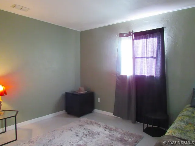 a view of an empty room with window and stairs