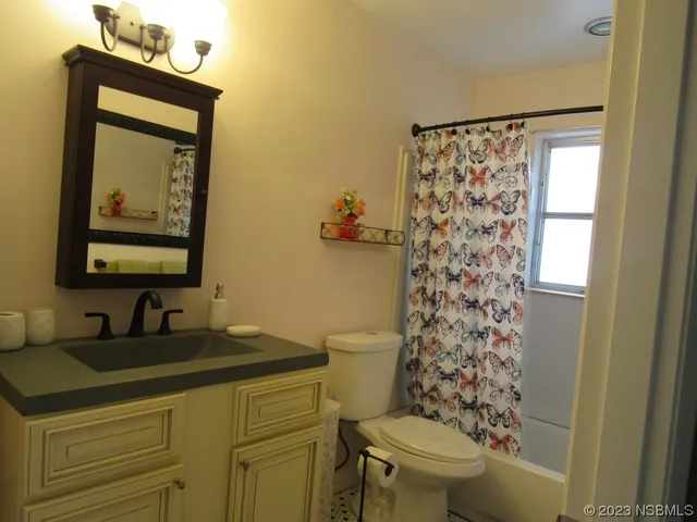a bathroom with a sink a toilet and shower curtain