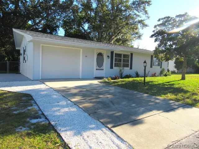 a view of a yard in front of a house with large trees