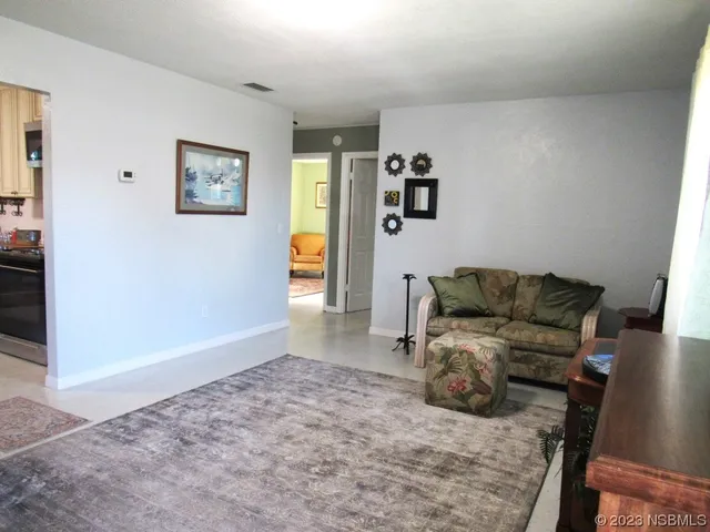 a living room with furniture and a refrigerator