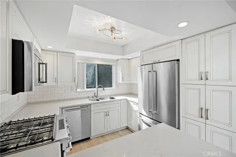 a kitchen with a refrigerator sink and cabinets