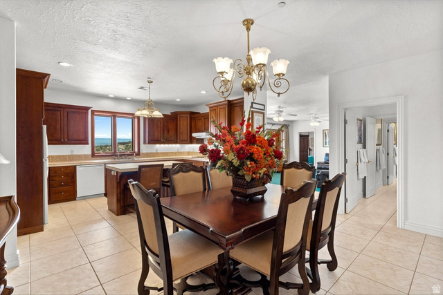 5615 East Eight Mile Gap Road Kanab, UT 84741 - Photo 54 of 81 Dining space featuring a chandelier, ceiling fan, a textured ceiling, and light tile patterned floors