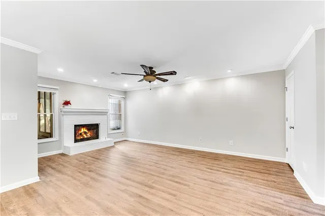 an empty room with windows and fireplace