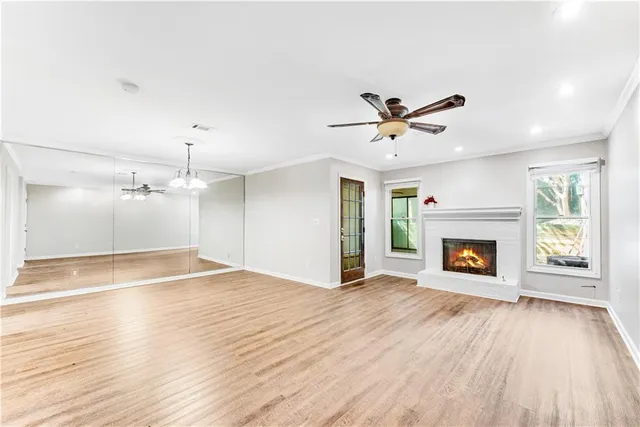 an empty room with fan and windows