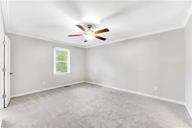 an empty room with windows and chandelier fan