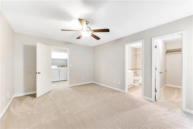 a view of empty room with wooden floor and ceiling fan