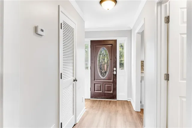 a view of a hallway with wooden floor and a bathroom
