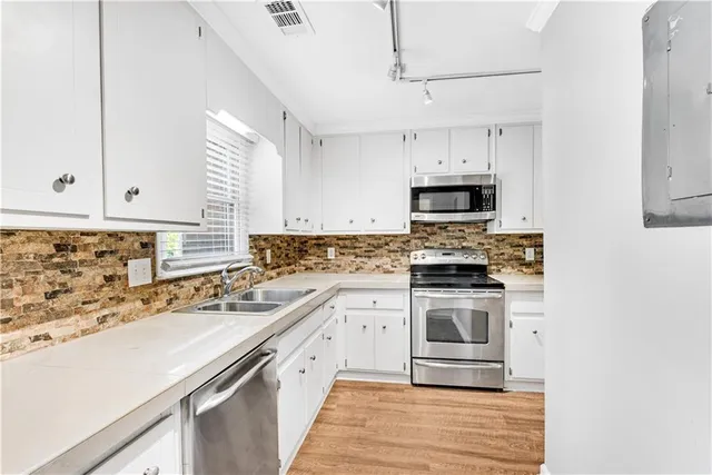 a kitchen with stainless steel appliances granite countertop a stove a sink and a microwave