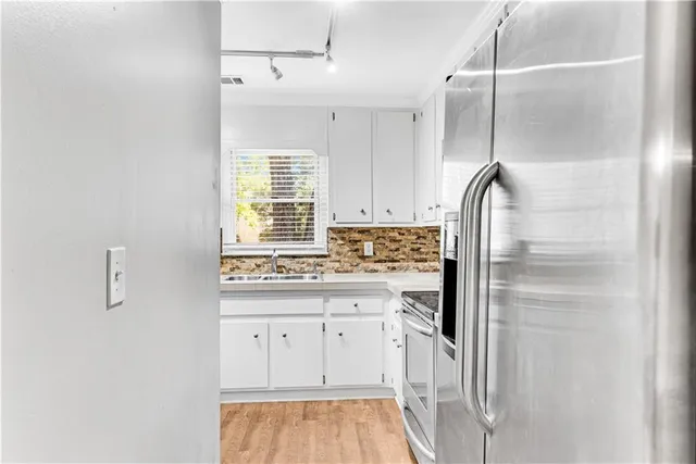 a kitchen with cabinets and a refrigerator