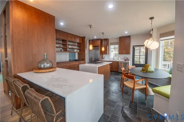 a kitchen with stainless steel appliances granite countertop a stove a sink a refrigerator and a refrigerator