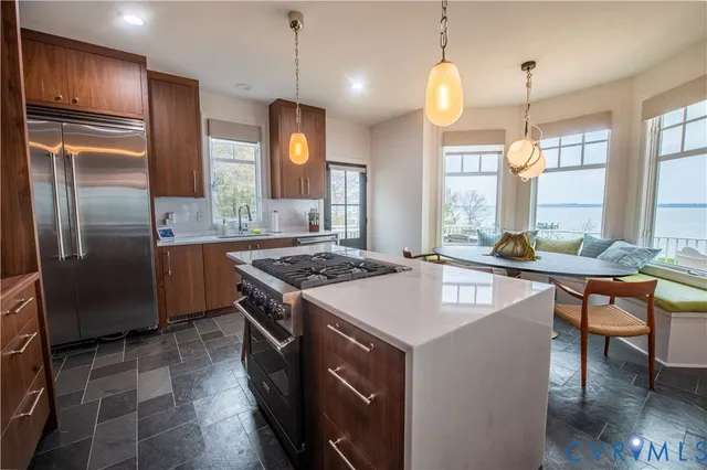 a kitchen with stainless steel appliances kitchen island granite countertop a stove a sink dishwasher and a microwave with wooden floor