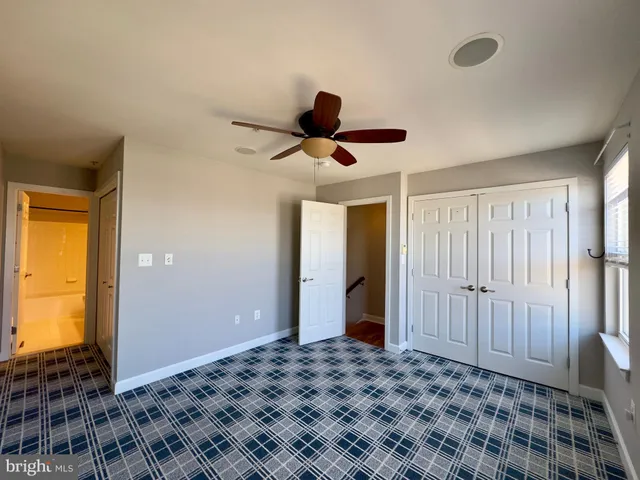 a bedroom with a bed and a lamp on closet