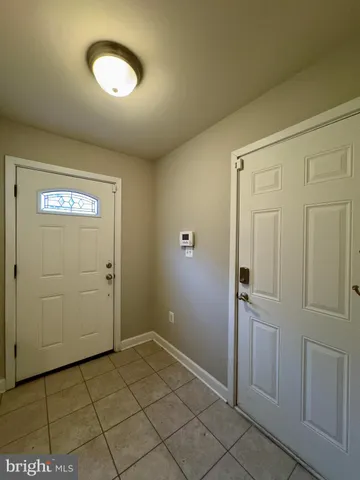 an empty room with wooden floor and mirror