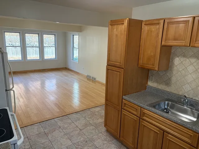 a view of a kitchen with wooden floor and a sink