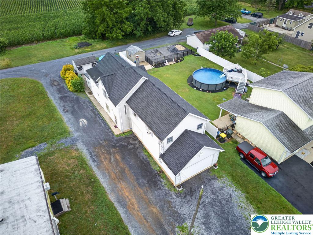 2628 Levans Road Coplay, PA 18037 - Photo 5 of 54 An aerial perspective reveals a charming residence with an inviting above-ground pool, nestled amidst verdant landscaping.