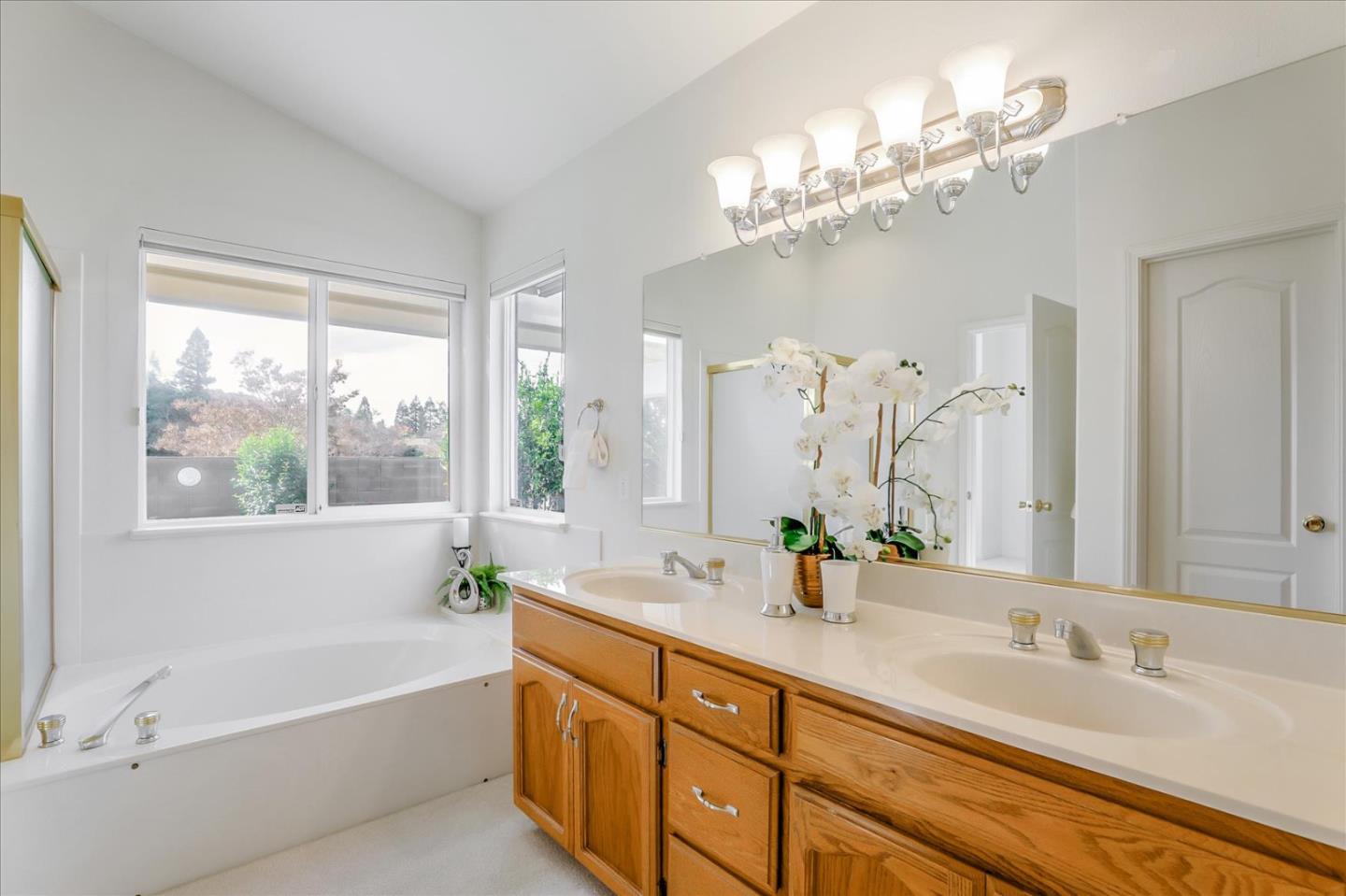883 Marcella Street Livermore, CA 94550 - Photo 24 of 44 a bathroom with a tub a double vanity sink and a large mirror