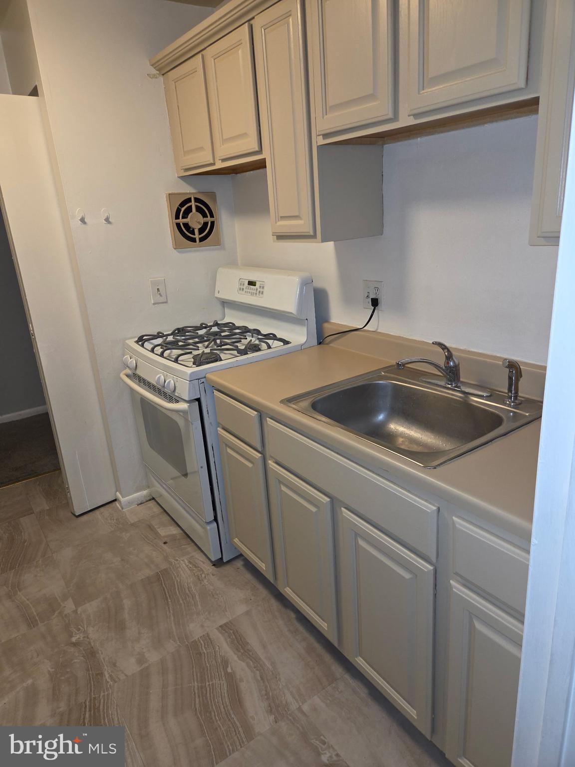204 St Barnabas Road, Unit T Suitland, MD 20746 - Photo 4 of 10 a kitchen with white cabinets and sink