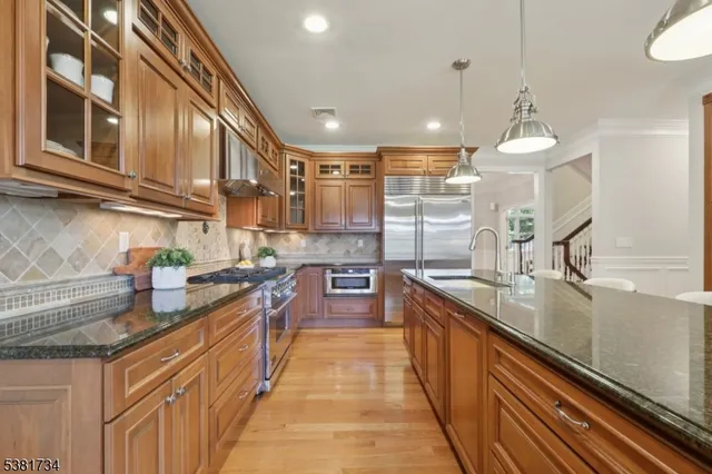 a large kitchen with stainless steel appliances granite countertop a sink and stove
