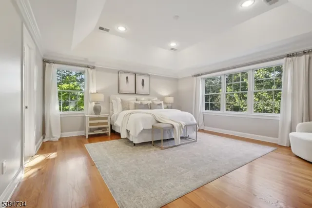 a bed sitting in a spacious bedroom next to a window