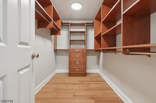 a view of a hallway with closet and wooden floor