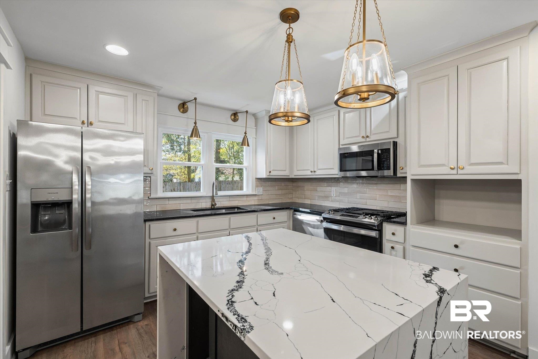3933 Radnor Avenue Mobile, AL 36608 - Photo 11 of 36 Kitchen with appliances with stainless steel finishes, tasteful backsplash, white stone countertops with nature's design, a kitchen island, and pendant and recessed lighting .. imagine cooking and entertaining here!